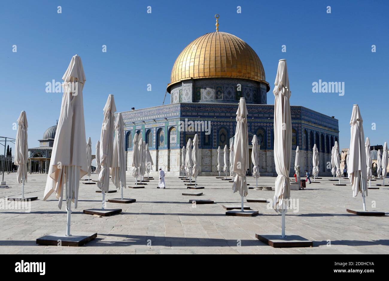 Palestinians walk amongst parasols placed outside the Dome of the Rock on the compound know to Muslims as 'al-Haram al-Sharif' and to Jews as 'Temple Mount' in Jerusalem's Old City June 27, 2013. REUTERS/Baz Ratner (JERUSALEM - Tags: RELIGION SOCIETY TRAVEL) Stock Photo