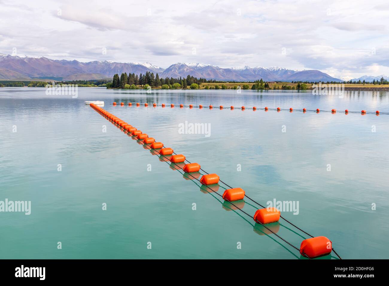 A row of red buoys floating on the water reservoir of Lake Ruataniwha, to protect the inlet to the turbines of the dam at Omarama, Twizel, New Zealand Stock Photo