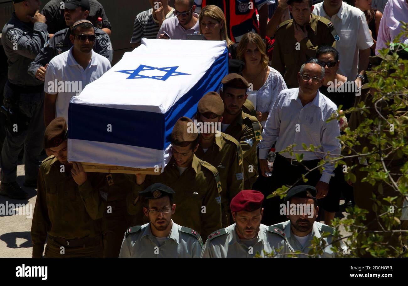 Israeli soldiers from the Golani Brigade carry the flag-draped coffin of their fallen comrade Max Steinberg during his funeral at Mount Herzl military cemetery in Jerusalem July 23, 2014. Steinberg, a 23 year-old American from California's San Fernando Valley, was among 13 Israeli Defense Forces soldiers killed on Sunday during fighting in Gaza. REUTERS/Siegfried Modola (JERUSALEM - Tags: CONFLICT POLITICS CIVIL UNREST MILITARY) Stock Photo