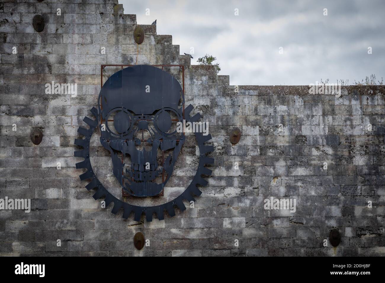 A steel plate cut-out of a crown-wheel and skull in front of the Steampunk Headquarters in Oamaru, Otago, New Zealand Stock Photo