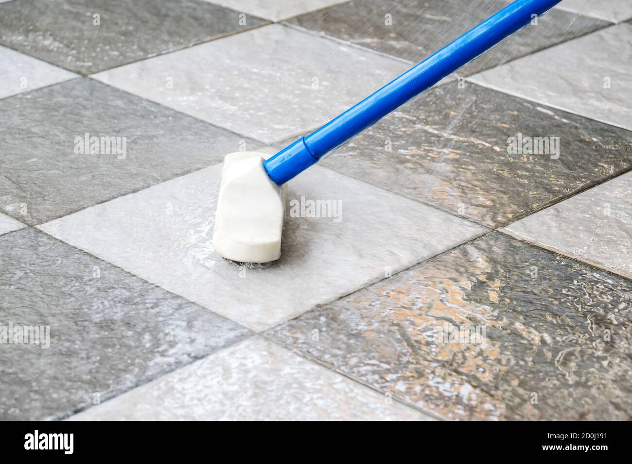 Cleaning the tile floor with floor scrubber brush Stock Photo - Alamy