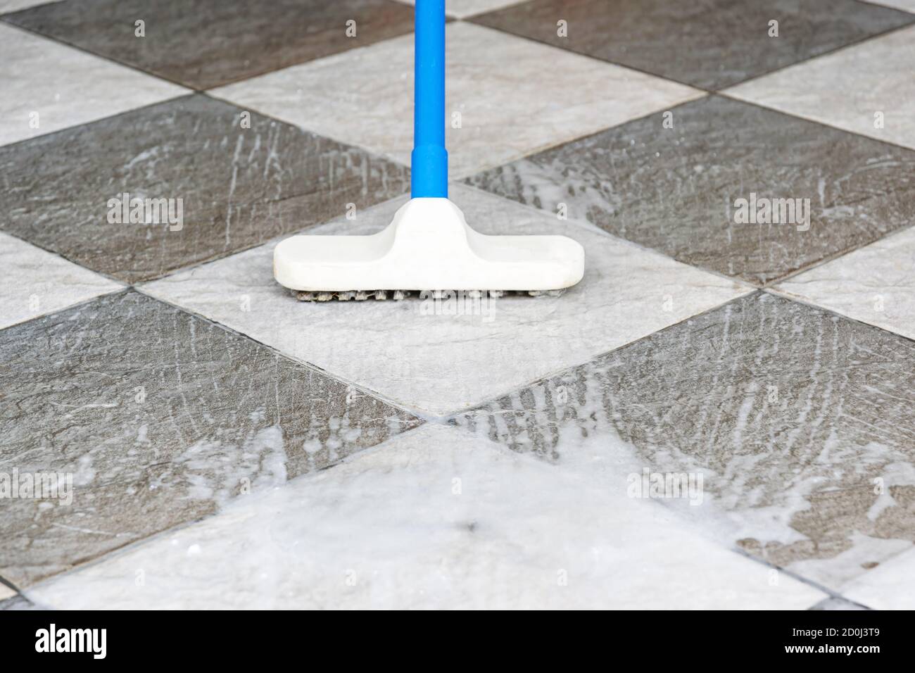 Cleaning the tile floor with floor scrubber brush Stock Photo - Alamy