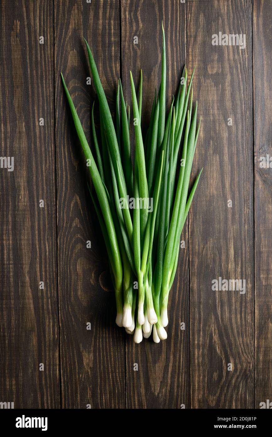 Fresh green onion on wooden background. Top view, flat lay Stock Photo