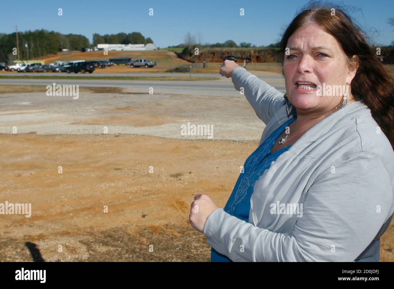 Ronda Wilbur, a neighbor of murder suspect Jimmy Lee Dykes, points as she  speaks with the media about encounters she's had with him at the scene of a  shooting and hostage taking