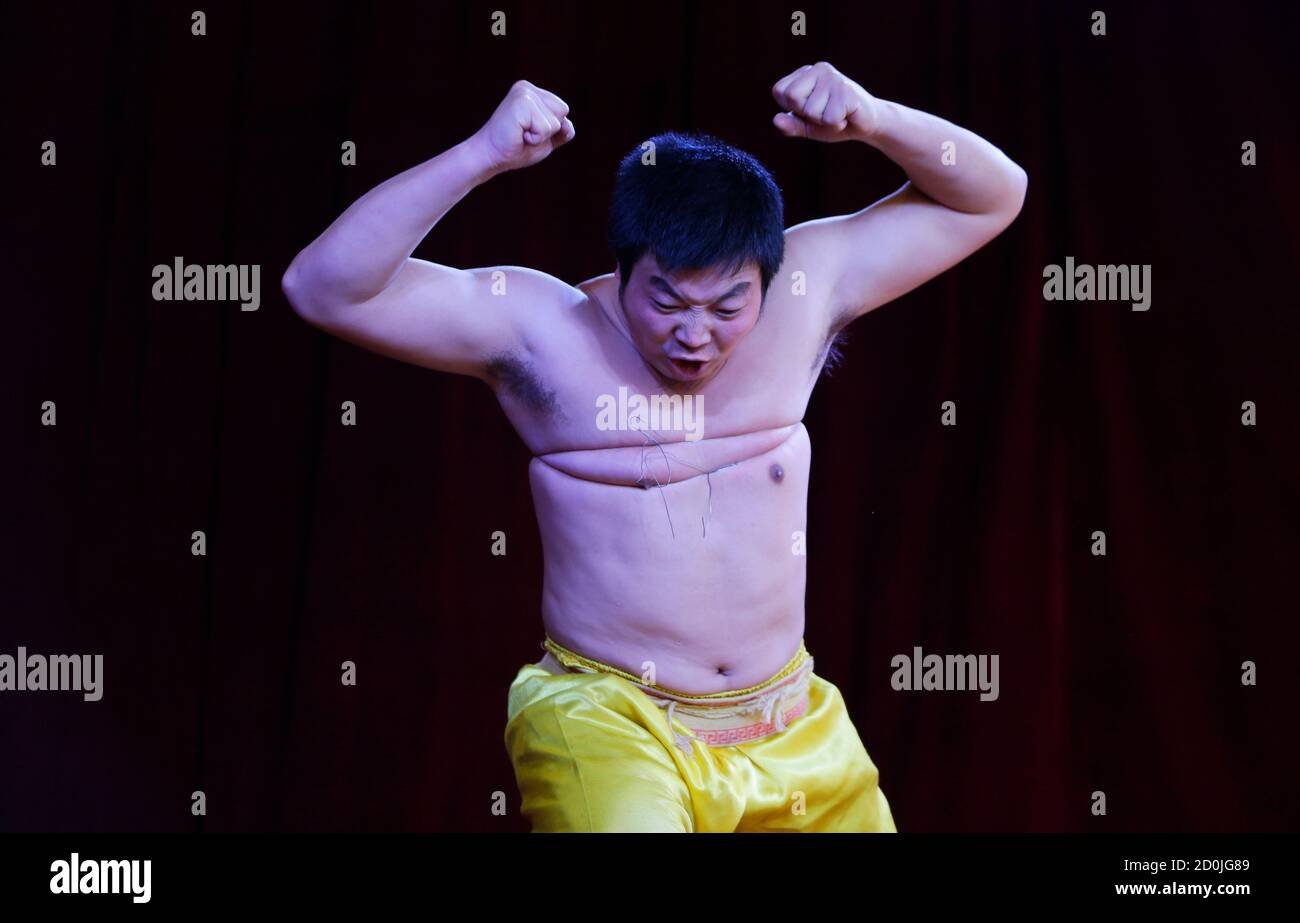 An acrobat tries to break an iron wire bound around his chest as he performs Qigong, a traditional form of Chinese martial arts, at a temple fair celebrating the traditional Chinese Spring Festival on the third day of the Chinese Lunar New Year at Daguanyuan park, in Beijing, February 2, 2014. REUTERS/Jason Lee (CHINA - Tags: SOCIETY) Stock Photo