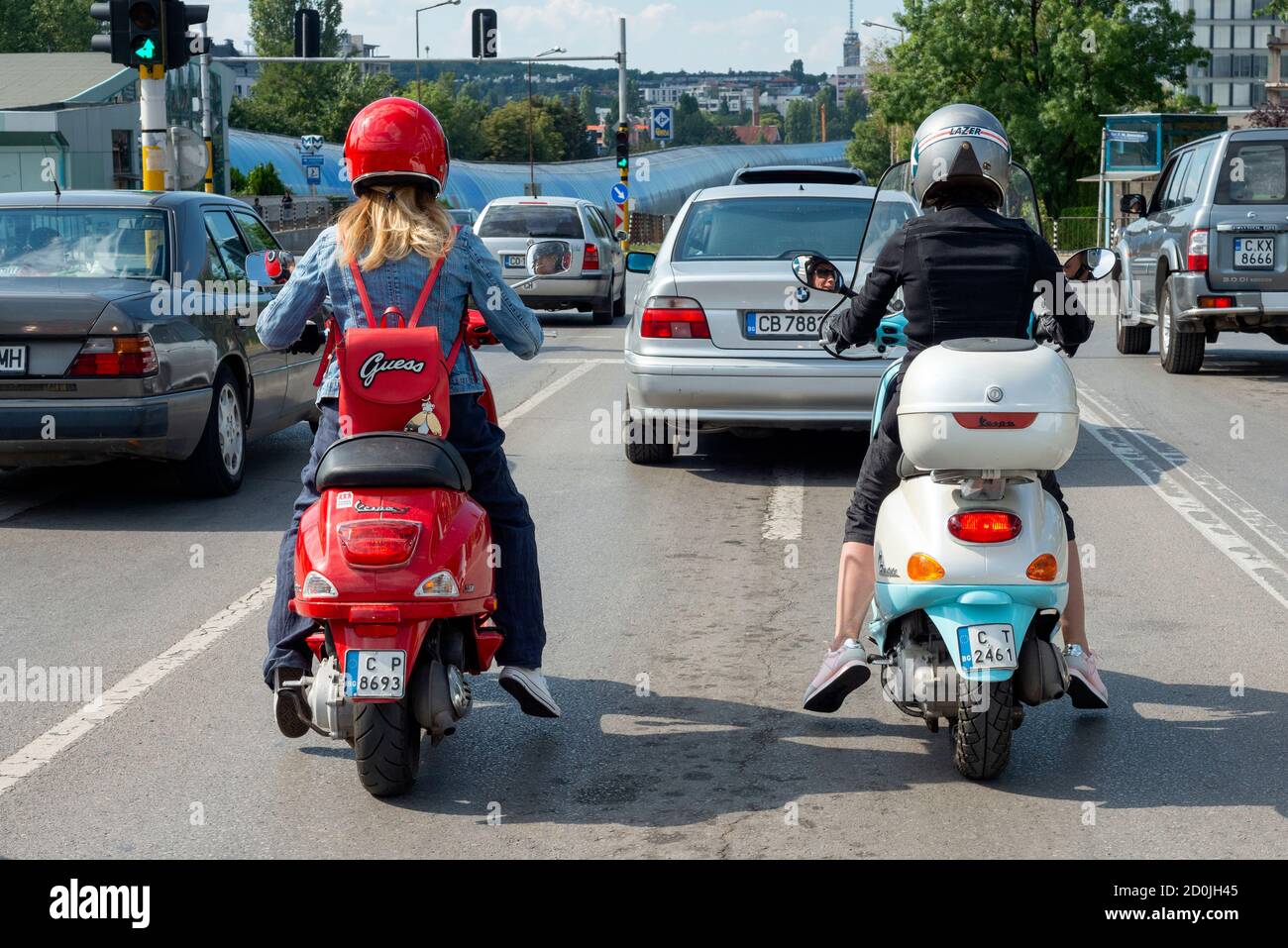 Street view of two female bikers riding Vespa scooters during rush hour in Sofia  Bulgaria as commute concept Stock Photo - Alamy