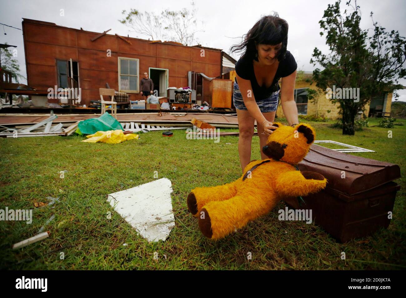 Melanie Cobb places on the ground her childhood teddy bear she retrieved from her grandmother's damaged home after Cyclone Marcia hit the coastal town of Yeppoon in northeastern Australia, February 20, 2015. Marcia slammed into northeast Australia on Friday, destroying homes, upending trees, cutting power lines and causing flash floods, while a second storm severered communications to a northern island where heavy damage was expected.    REUTERS/Jason Reed   (AUSTRALIA - Tags: ENVIRONMENT DISASTER) Stock Photo