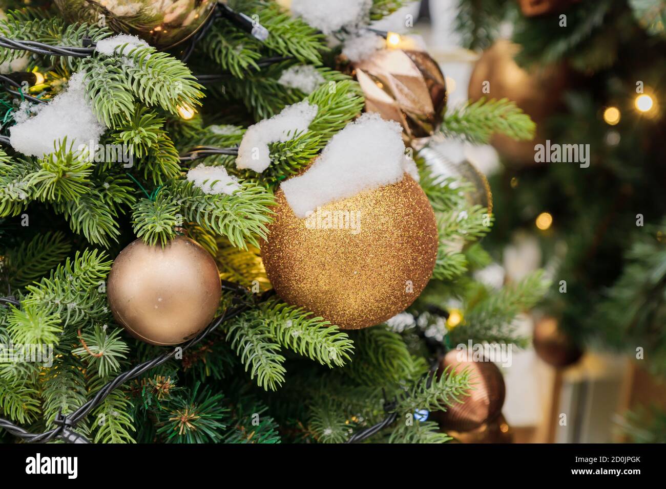 close up of christmas tree decorated with sparkling balls and garland ...