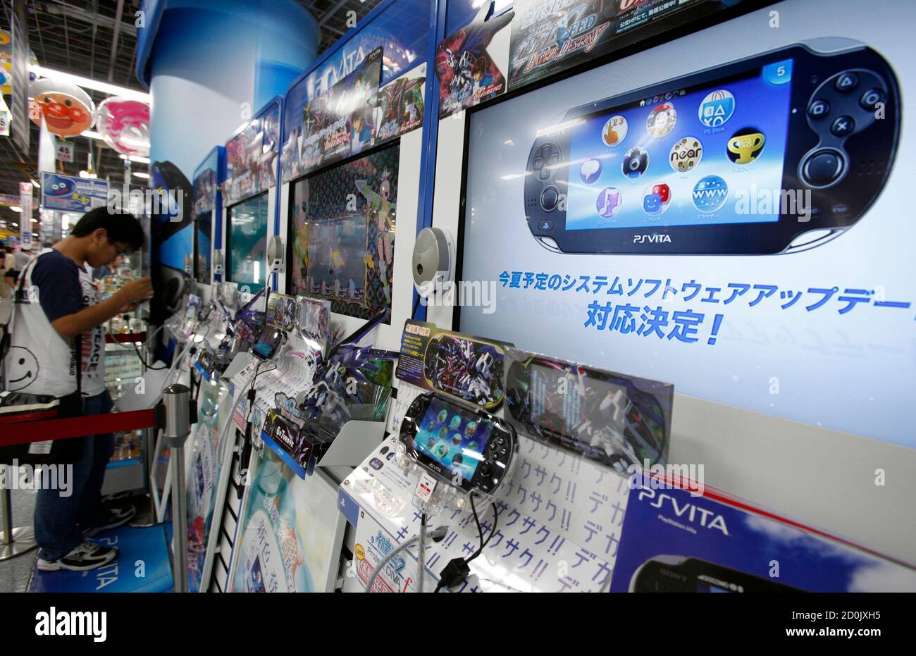 A customer plays a game on Sony Corp's Playstation Vita (PS VITA) at an  electronic store in Tokyo June 27, 2012. Sony Corp's new CEO, Kazuo Hirai,  on Wednesday defended retaining his