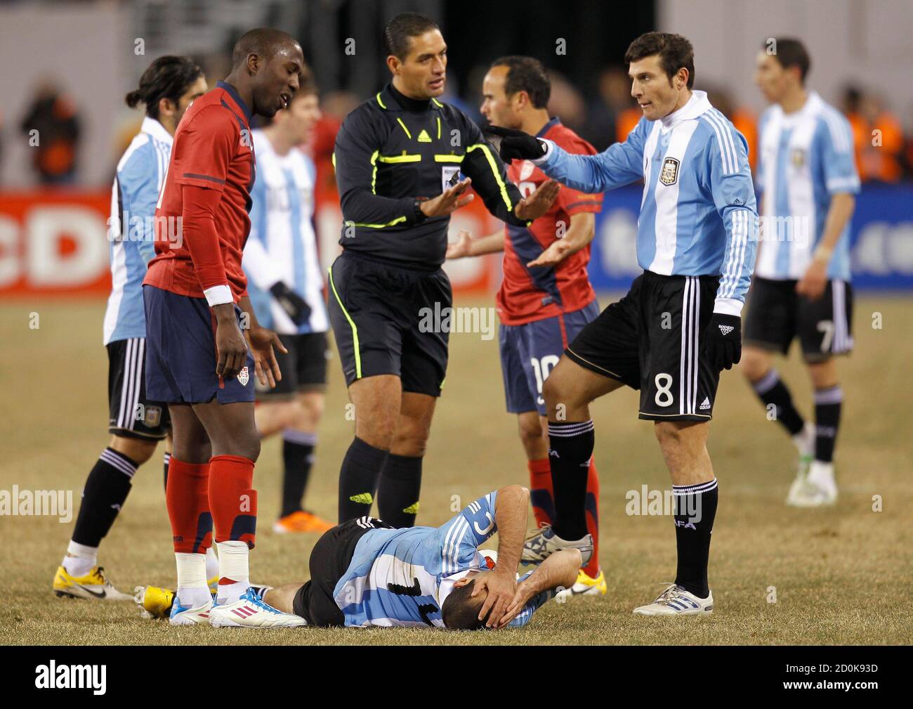 Argentina's Javier Mascherano lies on the ground as referee Roberto Garcia  Orozco of Mexico tries to keep Argentina's Javier Zanetti (R) from arguing  with Jozy Altidore (L) of the U.S., during their