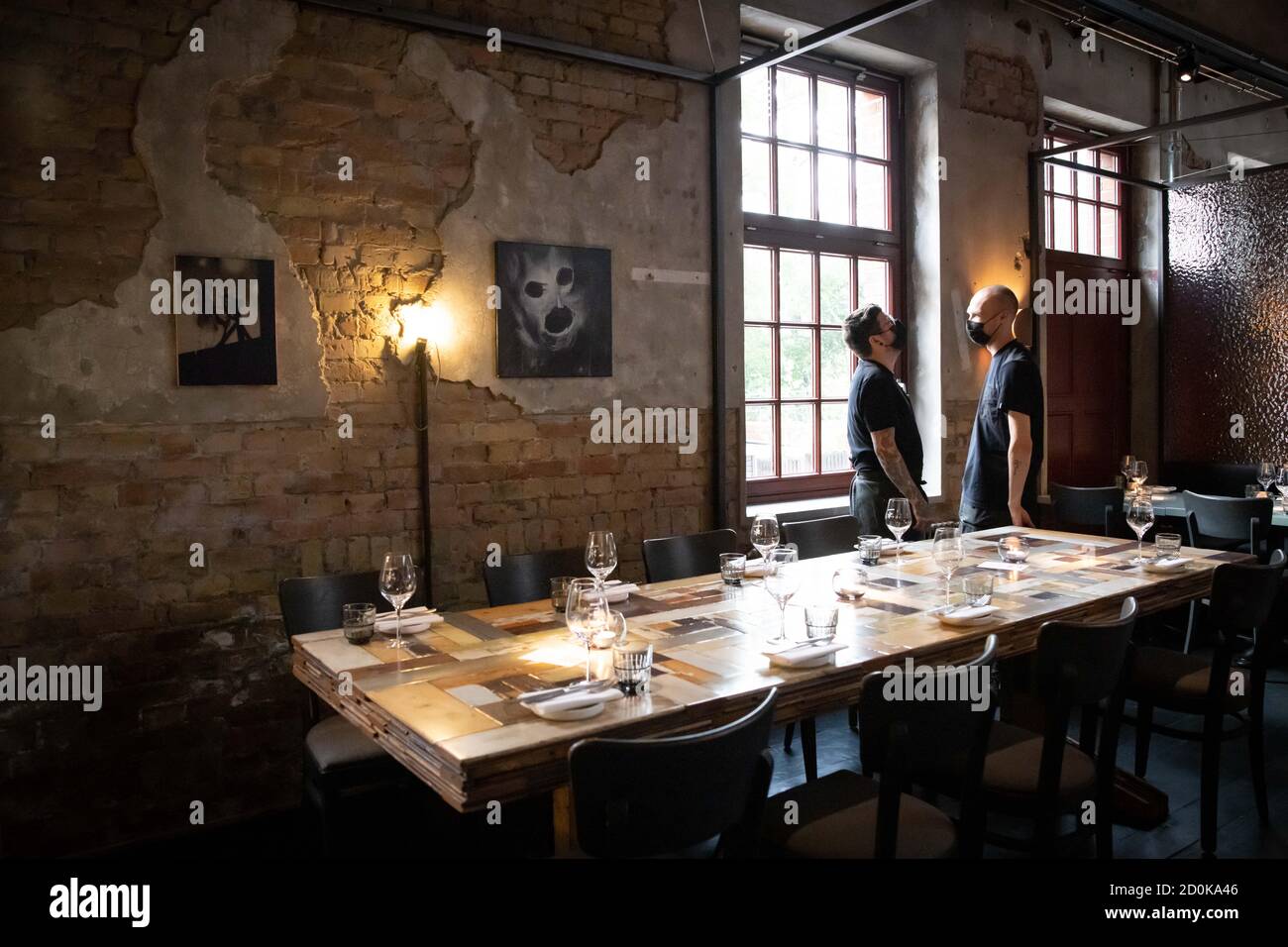 Hamburg, Germany. 02nd Oct, 2020. Service personnel set a table in the newly designed rooms of the restaurant 'Bullerei'. The restaurant of the Hamburg TV chef Tim Mälzer and his business partner Rüther reopened on 03.10.2020 after a six-month compulsory break. Credit: Christian Charisius/dpa/Alamy Live News Stock Photo