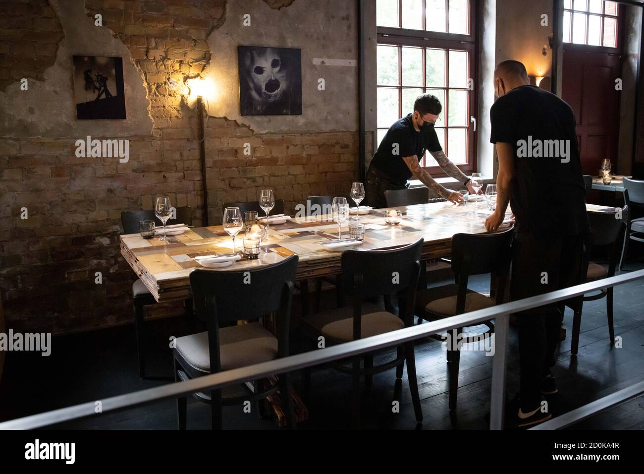 Hamburg, Germany. 02nd Oct, 2020. Service personnel set a table in the newly designed rooms of the restaurant 'Bullerei'. The restaurant of the Hamburg TV chef Tim Mälzer and his business partner Rüther reopened on 03.10.2020 after a six-month compulsory break. Credit: Christian Charisius/dpa/Alamy Live News Stock Photo