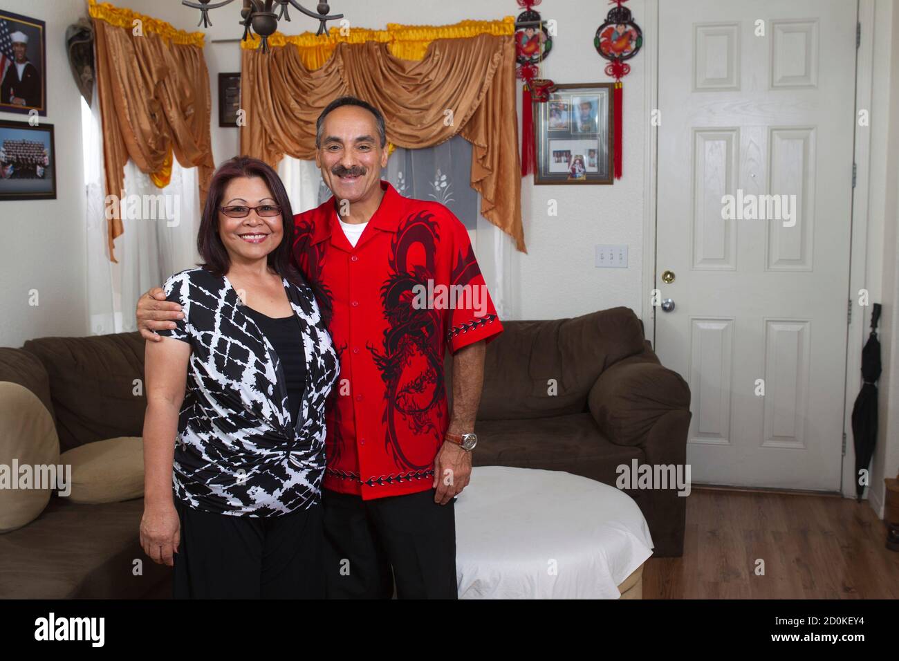 Felisa Medalla and Hubert Pereira pose in their home in Las Vegas, Nevada October 5, 2012. Pereira, 50, recently switched his registration from Democrat to 'nonpartisan' after suffering a yearlong bout of unemployment. Medalla, a waitress who was laid off seven months ago, complained: 'People say Obama is doing good. But how can he be doing good when I don't have a job?' Her question goes to the heart of why, despite President Barack Obama's recent uptick in the polls, his battle for reelection against Republican nominee Mitt Romney remains too close to call. Picture taken October 5, 2012. To  Stock Photo