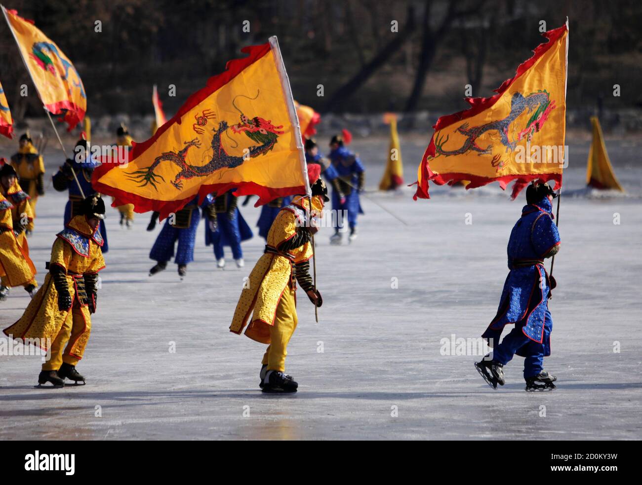 Performers dressed in Qing Dynasty (1644-1911) costumes hold dragon flags  as they skate on a frozen lake during a performance on the third day of the  Chinese Lunar New Year at the