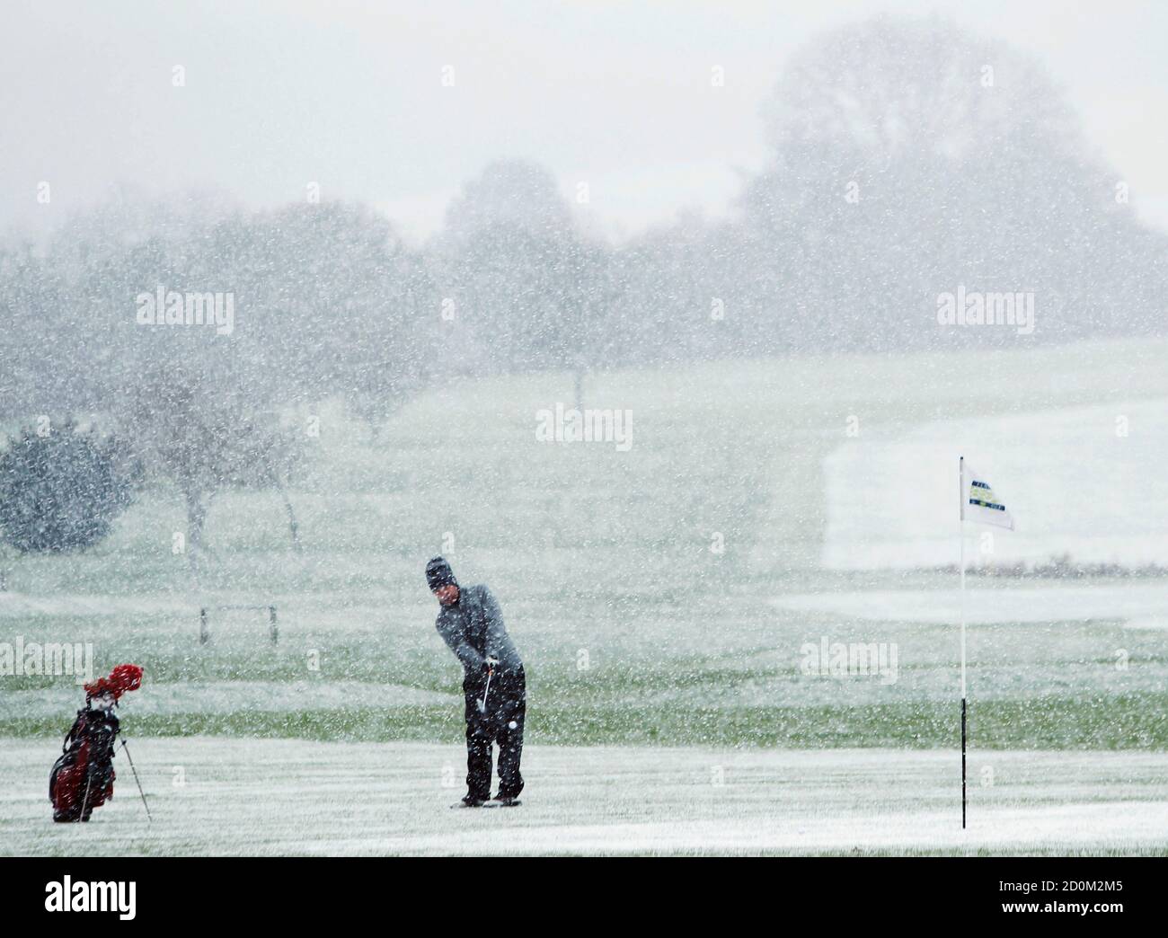 A man plays golf in snow at Etchinghill Golf Club near Folkestone in  southern England December 11, 2012. REUTERS/Luke MacGregor (BRITAIN - Tags:  ENVIRONMENT SPORT GOLF Stock Photo - Alamy