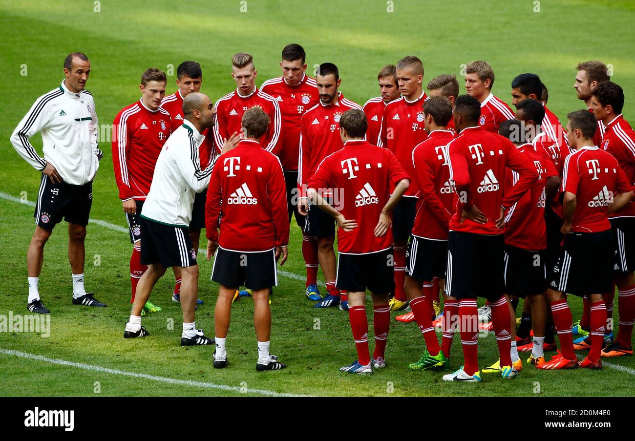 Bayern Munich new head coach Pep Guardiola (3rd L) talks to soccer players  during his first team training session, at the Allianz Arena in Munich June  26, 2013. Treble-winning Bayern Munich unveiled