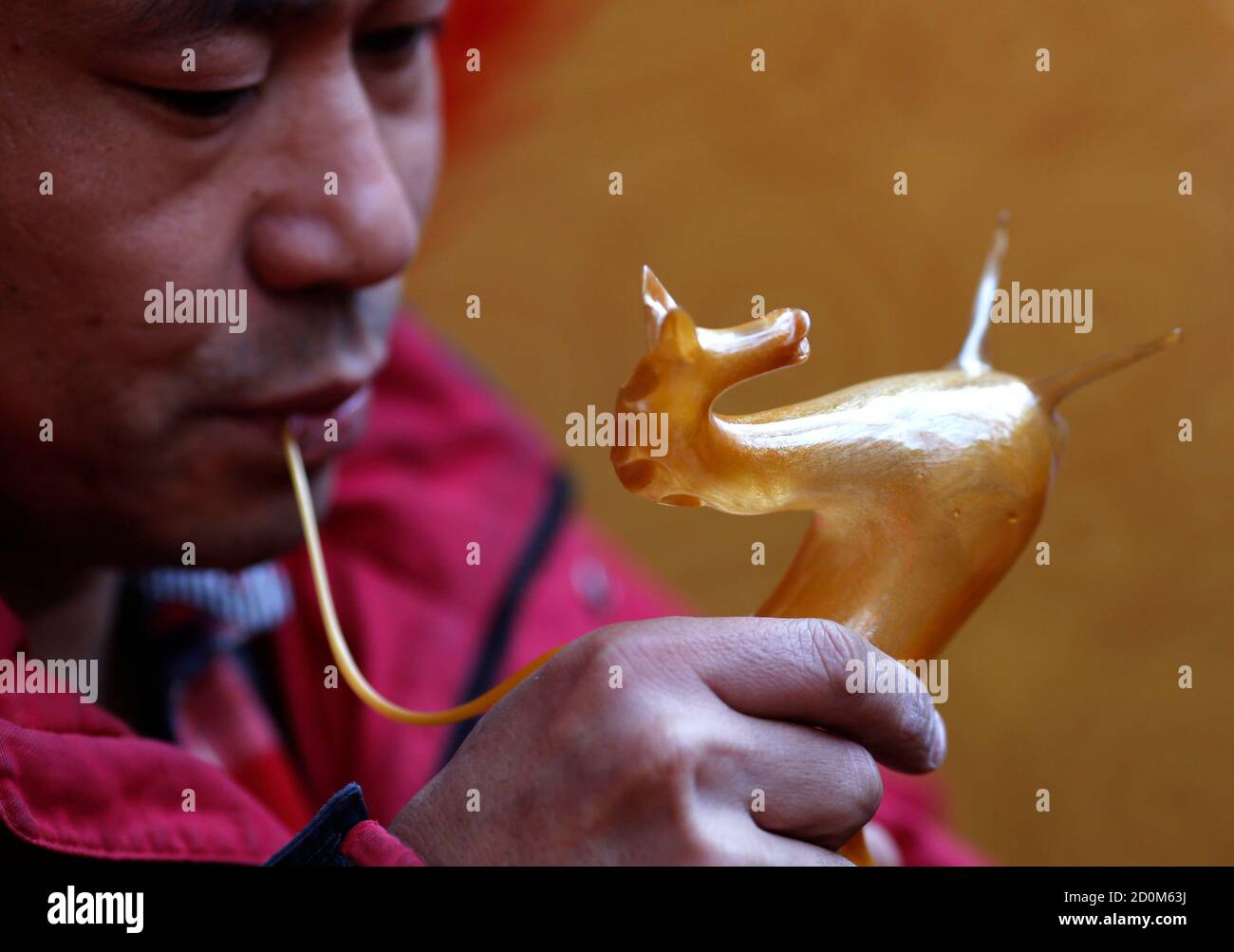 Folk artist Hou Gouyi blows boiled sugar to form the shape of a horse at a temple fair for the traditional Chinese Spring Festival on the third day of the Lunar New Year at Ditan Park, also known as the Temple of Earth, in Beijing February 2, 2014. Sugar sculpture blowing is a traditional Chinese folk art where artists blow and sculpt hot sugar to create three-dimensional figures. The Lunar New Year, or Spring Festival, began on January 31 and marked the start of the Year of the Horse, according to the Chinese zodiac.   REUTERS/Kim Kyung-Hoon (CHINA - Tags: ANNIVERSARY SOCIETY) Stock Photo