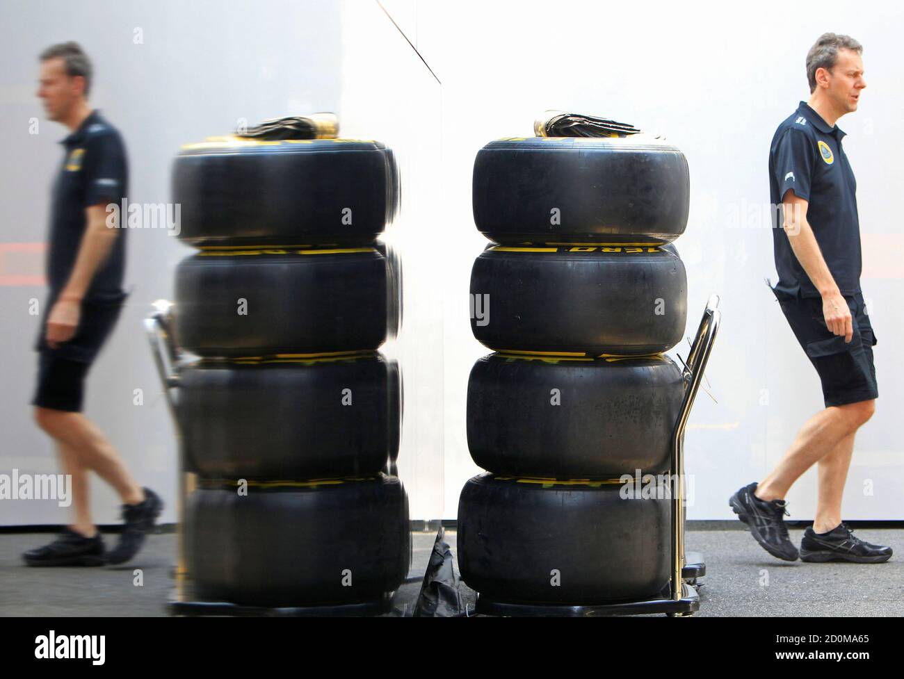 A technican walks past a pile of tyres at Lotus Formula One team's paddock after the first practice session of the Hungarian F1 Grand Prix at the Hungaroring circuit, near Budapest, Hungary July 24, 2015. Lotus team blamed a banking technicality for a delay in Pirelli releasing tyres to them ahead of first Hungarian Grand Prix practice on Friday. The team received their tyres less than an hour before cars went out on track at the Hungaroring. REUTERS/Bernadett Szabo Stock Photo