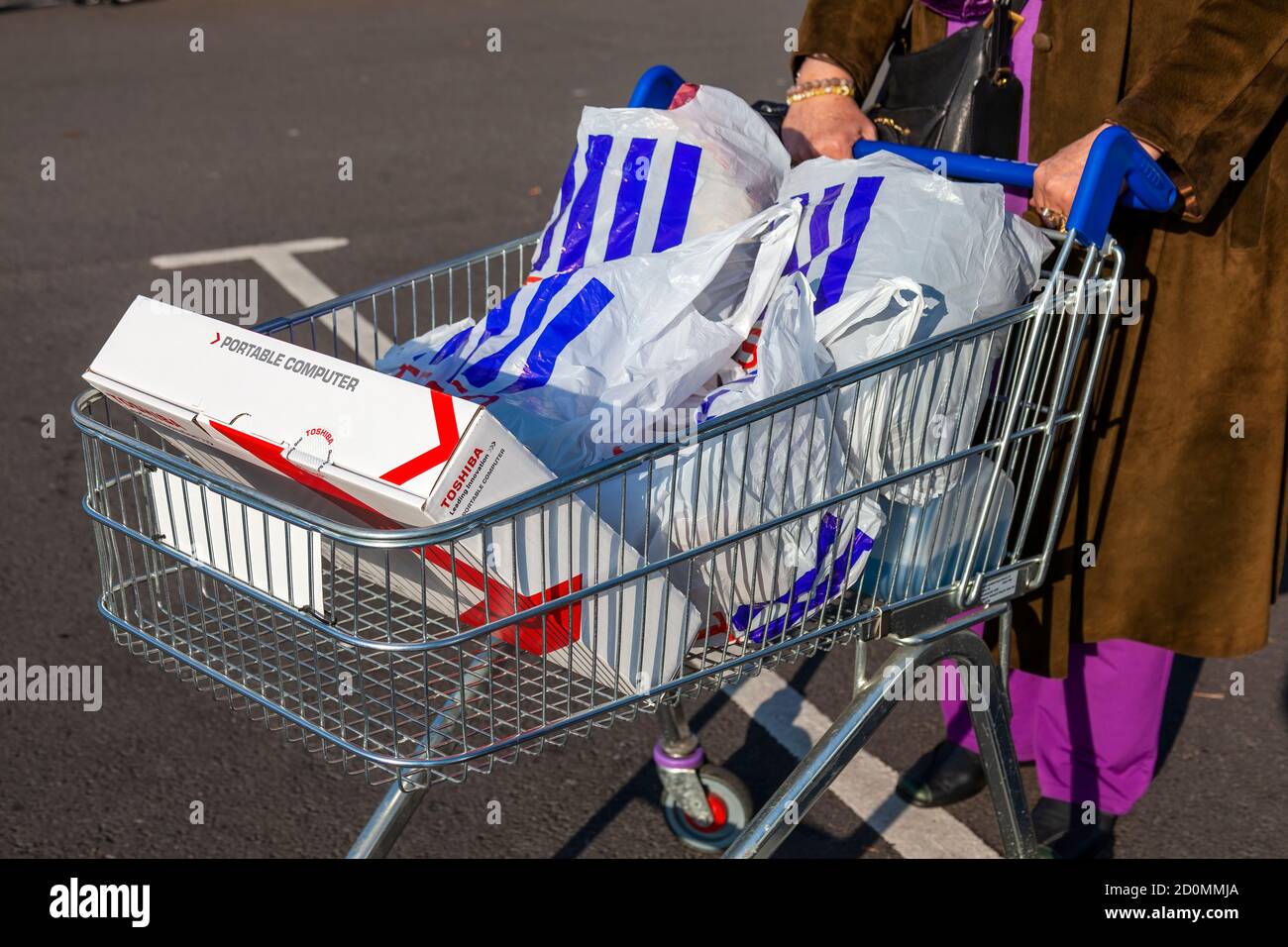 London, UK, November 19, 201 : Customer shopper pushing a shopping trolley  cart full of plastic carrier bags at its Tesco Extra supermarket retail bus  Stock Photo - Alamy
