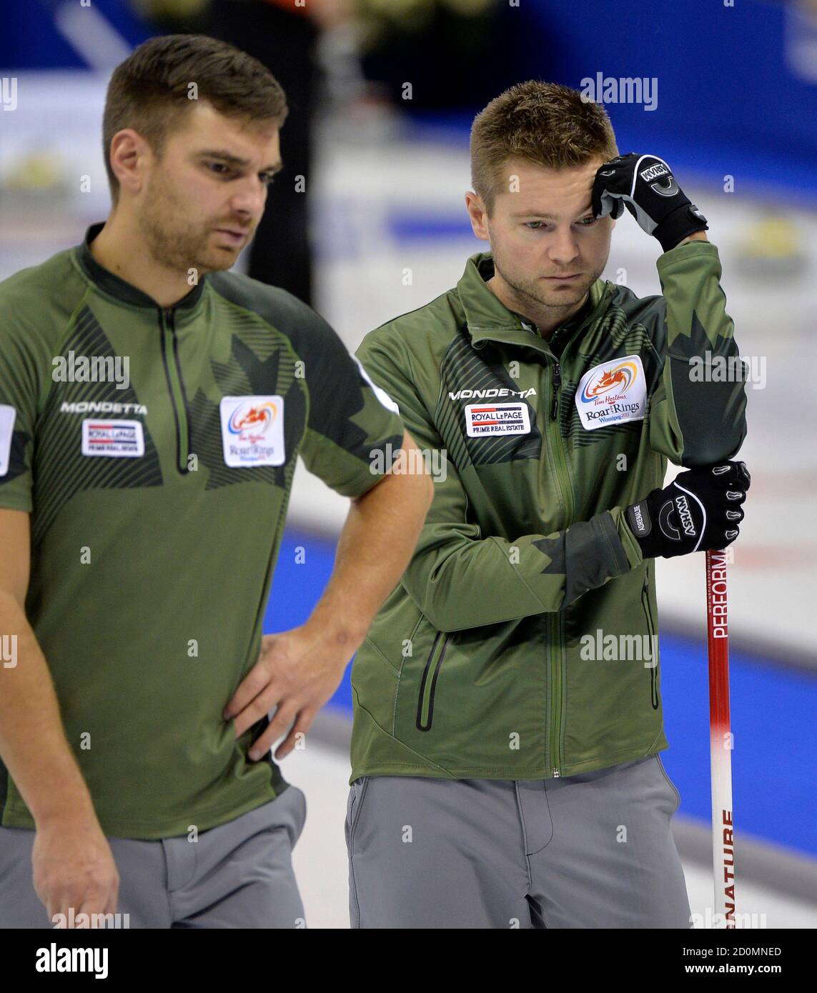 Skip Mike McEwen (R) and second Matt Wozniak look over their next shot  against Team Koe during draw 14 at the Roar of the Rings Canadian Olympic  Curling Trials in Winnipeg, December