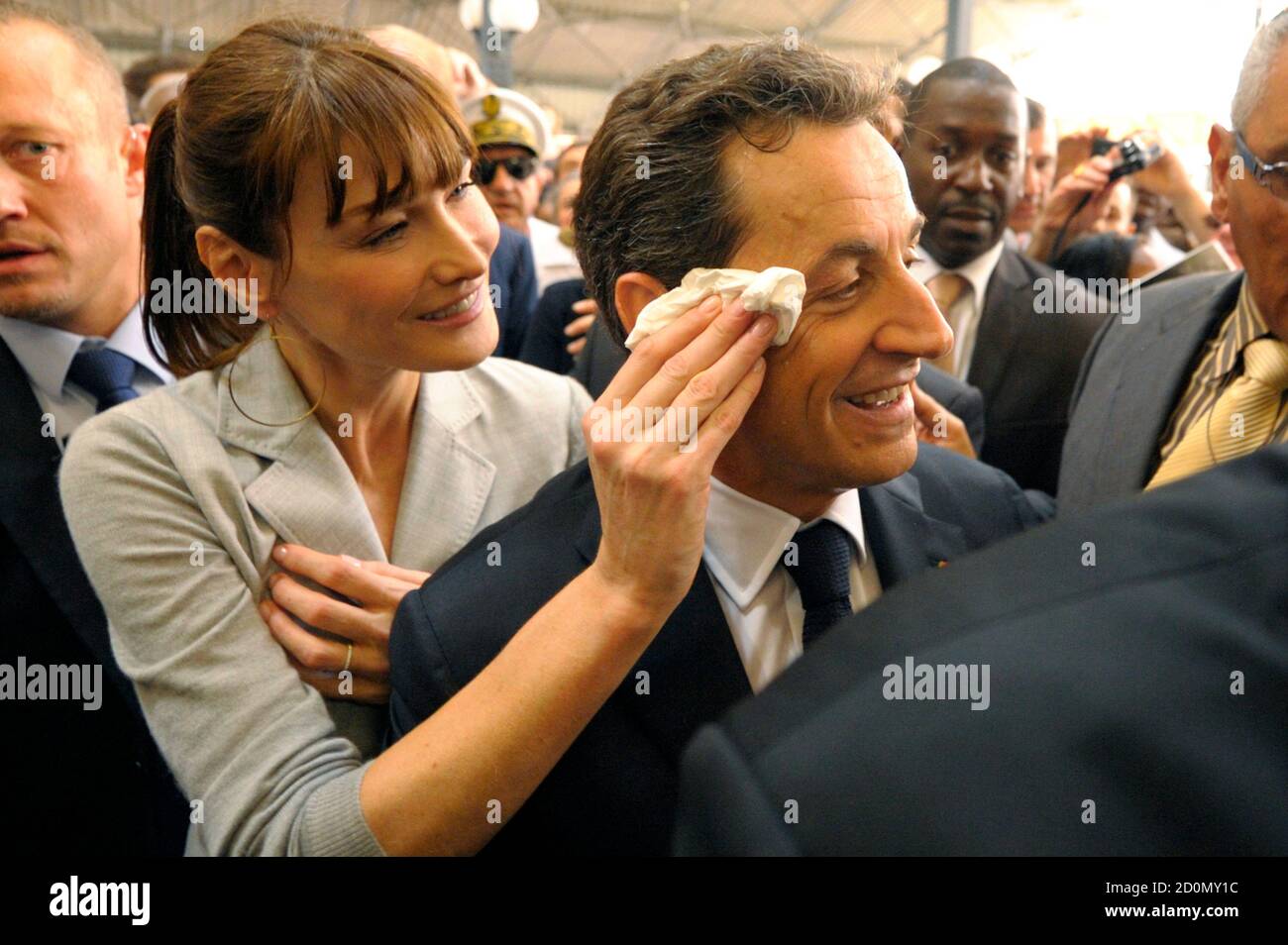 France's First Lady Carla Bruni-Sarkozy wipes the brow of her husband,  France's President Nicolas Sarkozy, as they visit a market in  Fort-de-France on the Martinique island January 8, 2011. Sarkozy and his