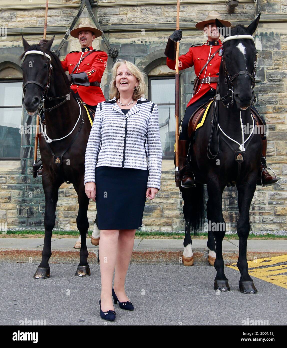Hannelore Kraft, President of the Federal Council of Germany and North Rhine-Westphalia's state premier, reacts while posing with Royal Canadian Mounted Police officers on horseback during a visit on Parliament Hill in Ottawa September 8, 2011.       REUTERS/Chris Wattie       (CANADA - Tags: POLITICS) Stock Photo