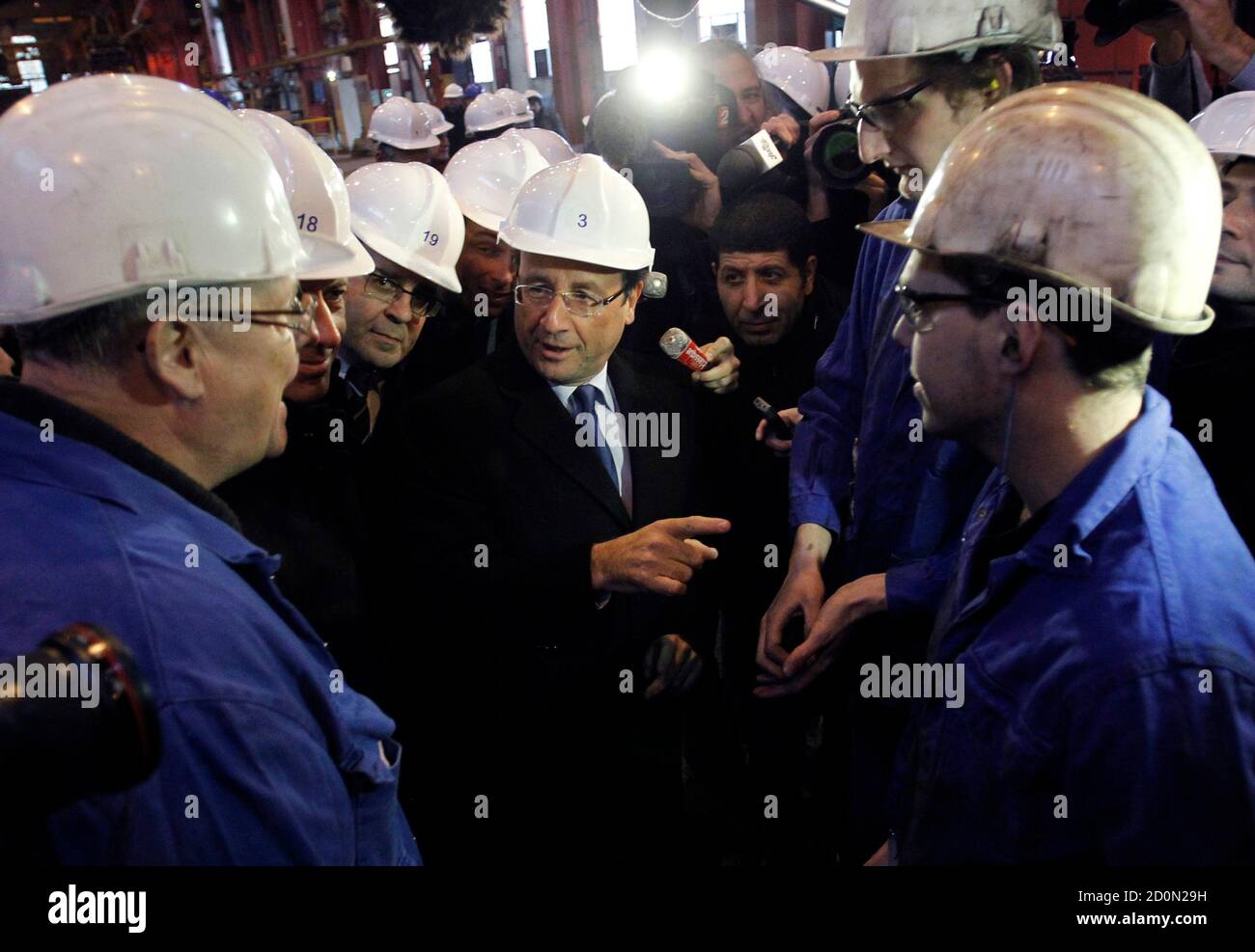Francois Hollande (C), Socialist Party candidate for the 2012 French presidential election, speaks with steel workers as he visits Akers, a steel factory, in Thionville, eastern France, January 17, 2012.    REUTERS/Christophe Ena/Pool   (FRANCE - Tags: POLITICS BUSINESS EMPLOYMENT) Stock Photo