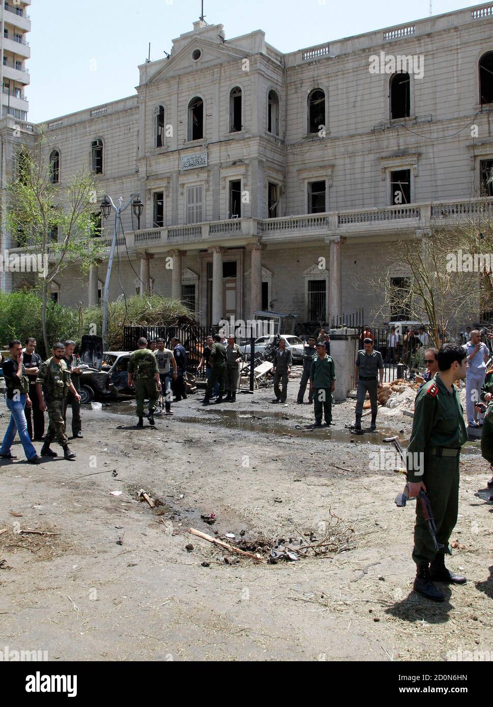 Security personnel walk near the former Interior Ministry building after a blast at Marjeh Square in Damascus April 30, 2013. The bomb in central Damascus killed 13 people on Tuesday, state television said, a day after Prime Minister Wael al-Halki survived an attack on his convoy in the heart of the Syrian capital. State television said 70 people were wounded, several critically. The British-based Syrian Observatory reported 9 dead civilians and 3 security men and said the death toll was likely to rise. REUTERS/Khaled al-Hariri (SYRIA - Tags: POLITICS CONFLICT) Stock Photo