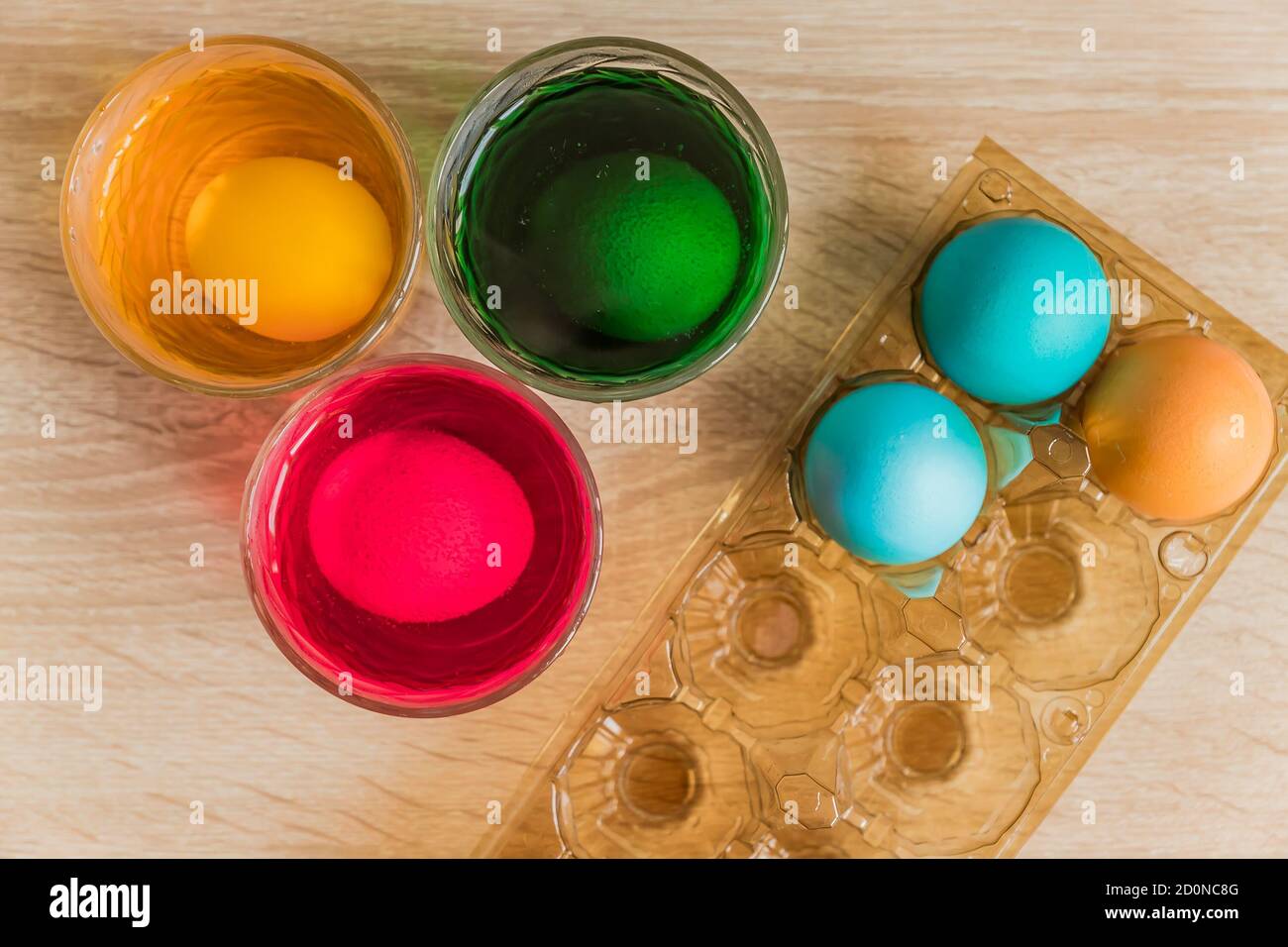 Glass with orange, red and green paint for Easter eggs. Easter Egg decorating. Stock Photo