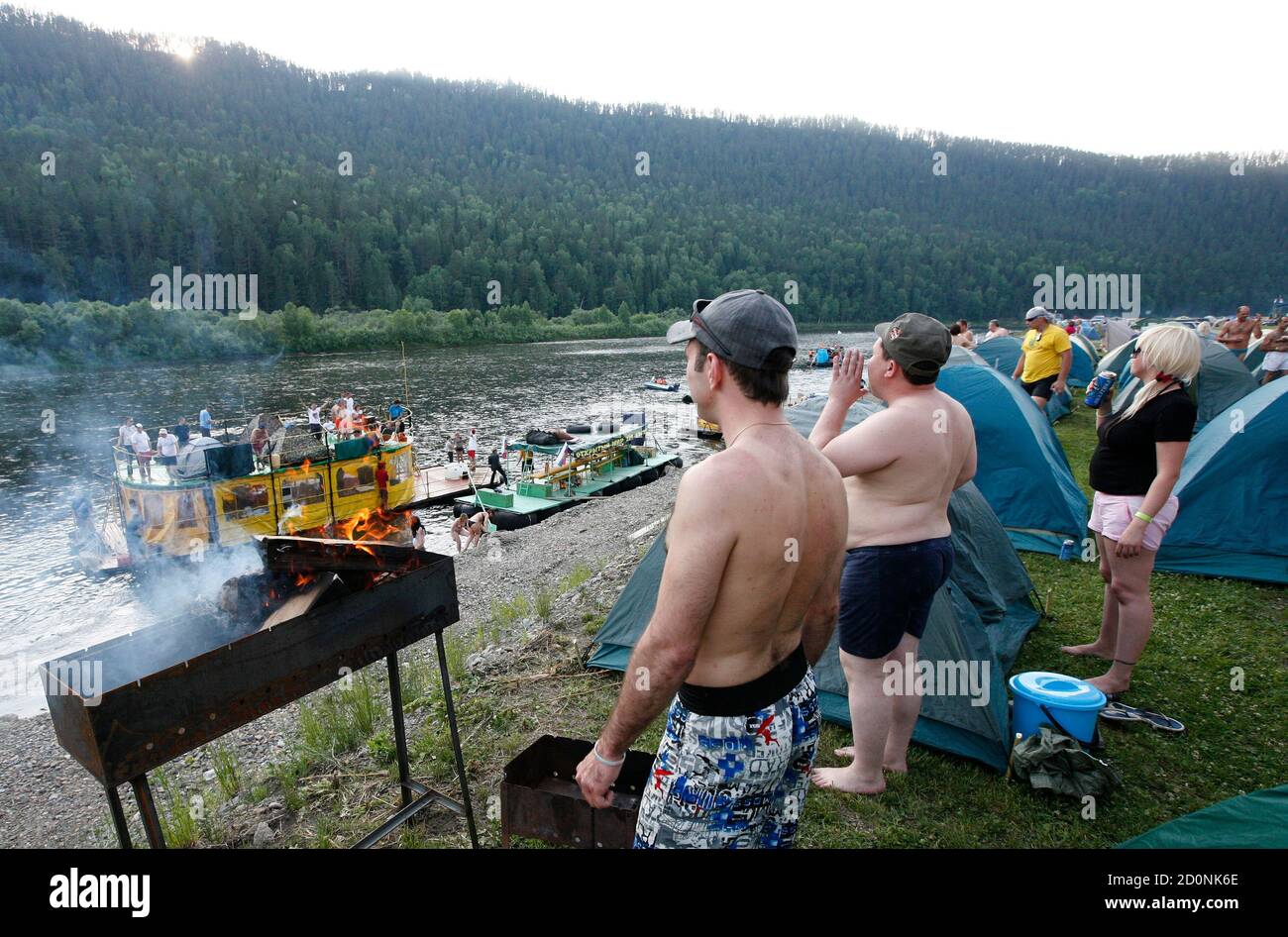 Participants of the annual Mansky tourist three-day-long festival,  dedicated to the opening of the amateur rafting season, watch rafts on the  Mana river near the settlement of Beret in the Siberian Taiga,