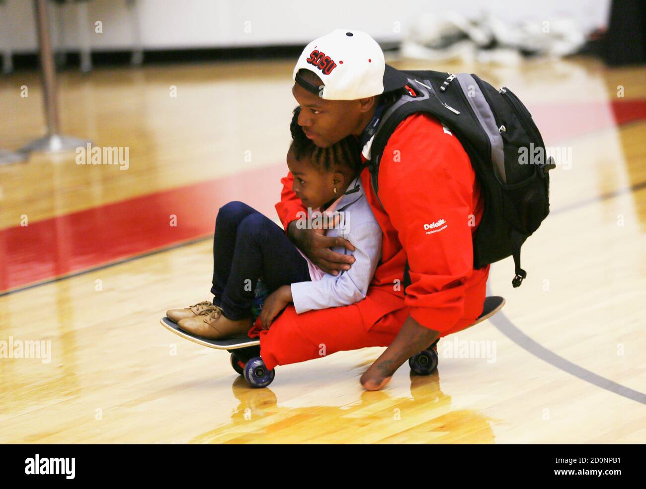 U.S. Marine Corps Sergeant Anthony McDaniel takes his daughter Dejah for a ride on his skateboard at the Warrior Games at the U.S. Olympic Training Center in Colorado Springs, Colorado May 11, 2013. McDaniel, who lost both legs and his left hand after stepping on an IED while serving in Afghanistan, will be competing in wheelchair basketball and track at the event. He recently decided the skateboard is sometimes easier to use to get around than a wheelchair. The Warrior Games is a Paralympic-style competition featuring injured servicemen and women from the U.S., United Kingdom, Canada and Aust Stock Photo
