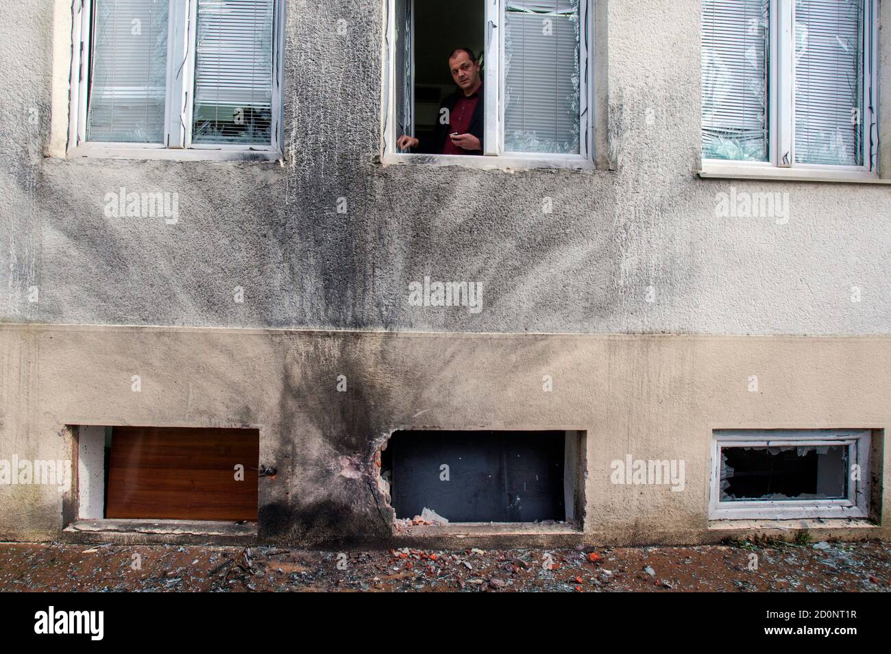 Editor-in-chief of Montenegro's leading daily Vijesti, Mihailo Jovovic  looks through a window damaged in a bomb blast overnight at the newspaper's  offices in Podgorica December 27, 2013. This is the latest attack