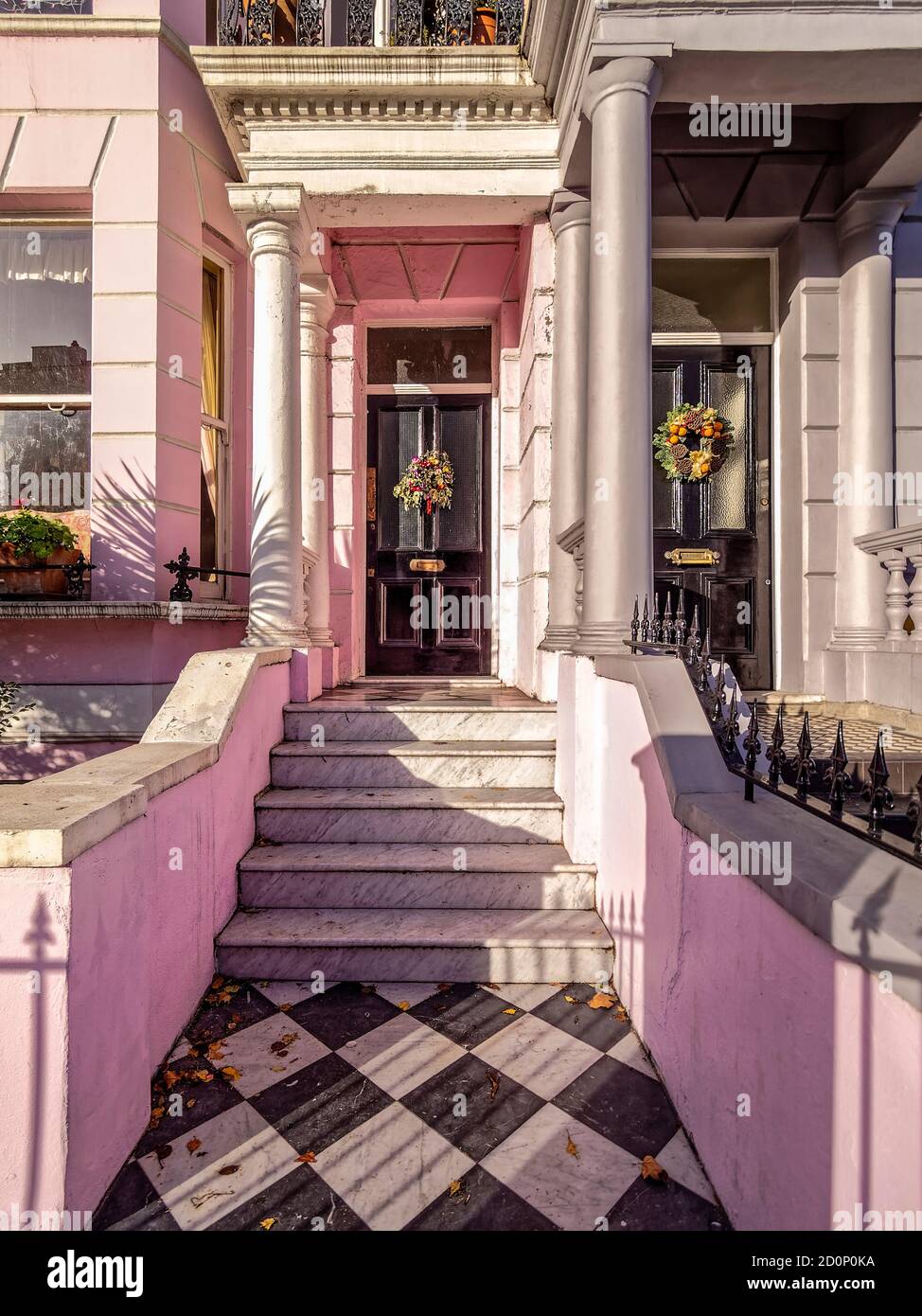 Sunny Christmas Day in Notting Hill. Two adjacent house entrances with festive Christmas decorations in London, United Kingdom. Stock Photo