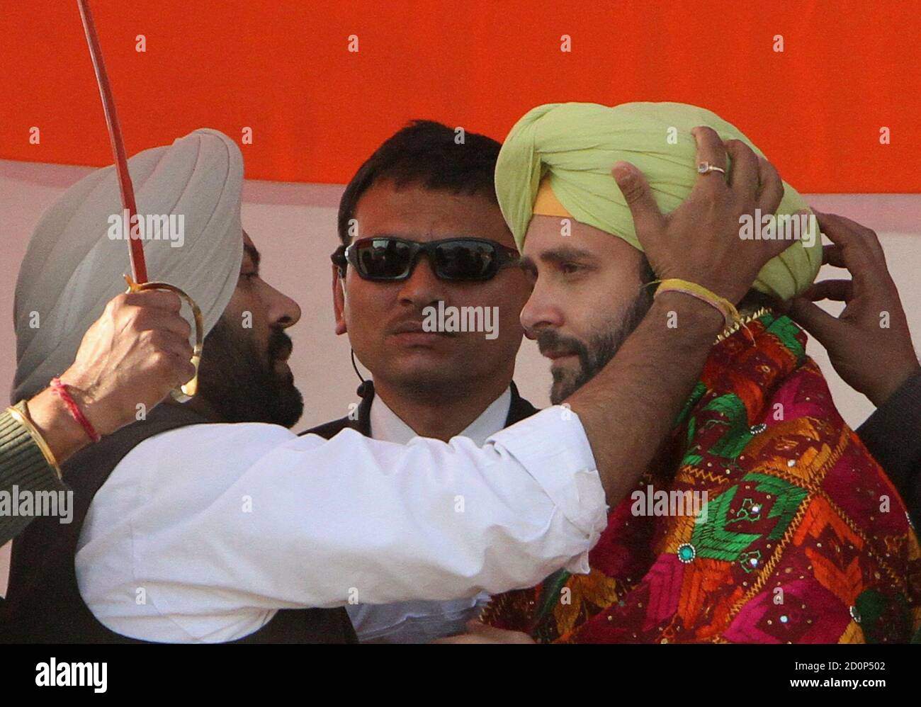 Rahul Gandhi (R), a lawmaker and son of Congress party chief Sonia Gandhi, is presented with a turban by his party supporters during a campaign rally ahead of state assembly elections at Sirhind in the northern Indian state of Punjab January 27, 2012.  REUTERS/Ajay Verma (INDIA - Tags: ELECTIONS POLITICS) Stock Photo