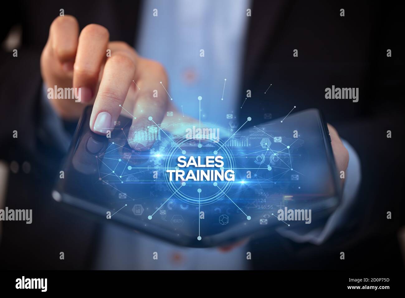 Businessman holding a foldable smartphone with SALES TRAINING inscription, new business concept Stock Photo