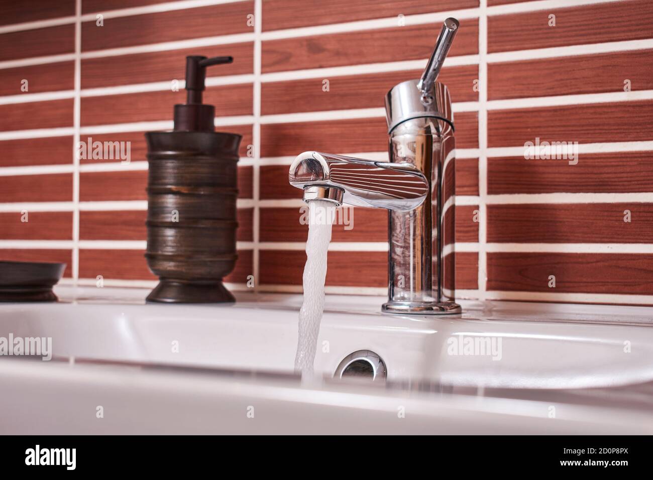 Open bathroom faucet wasting water in an action against the care of the environment Stock Photo