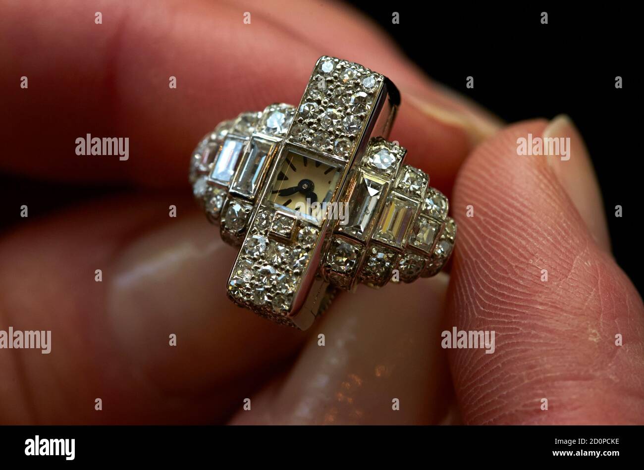 A staff member holds an Art Deco platinum ring watch set with diamonds  during an auction preview at Sotheby's in Geneva May 7, 2014. This item  made by Cartier around 1937 is