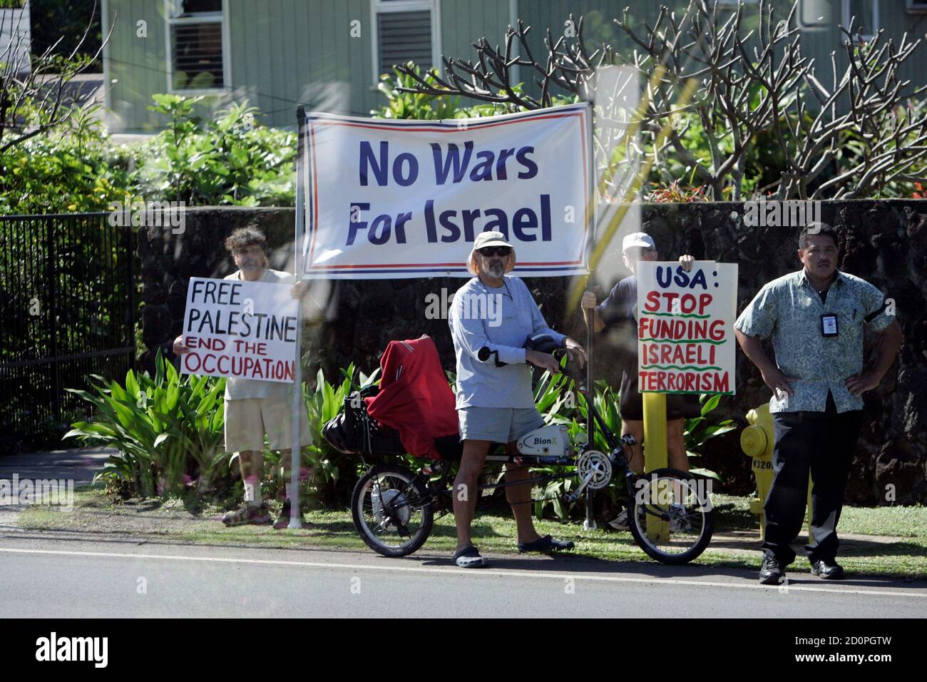 Protesters hold signs supporting Palestine as U.S. President Barack Obama's motorcade leaves the compound where he and his family are staying while on Christmas vacation in Hawaii in Kailua, Hawaii January 1, 2011. Picture shot through glass. REUTERS/Hugh Gentry (UNITED STATES - Tags: POLITICS CIVIL UNREST) Stock Photo