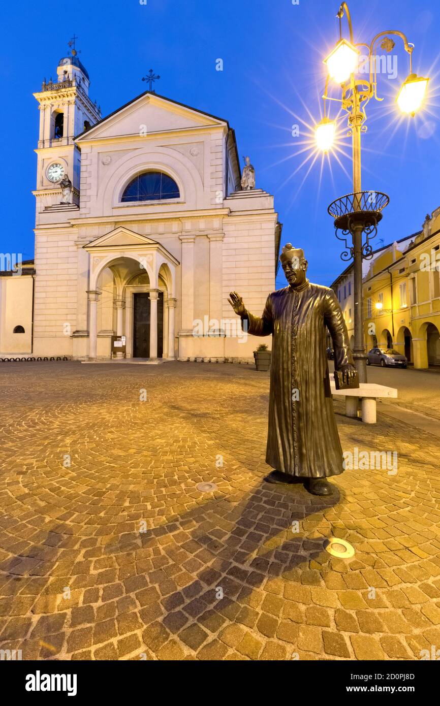 Brescello: the statue of Don Camillo and the Santa Maria Nascente church. The village is famous for the films of Don Camillo and Peppone. Italy. Stock Photo