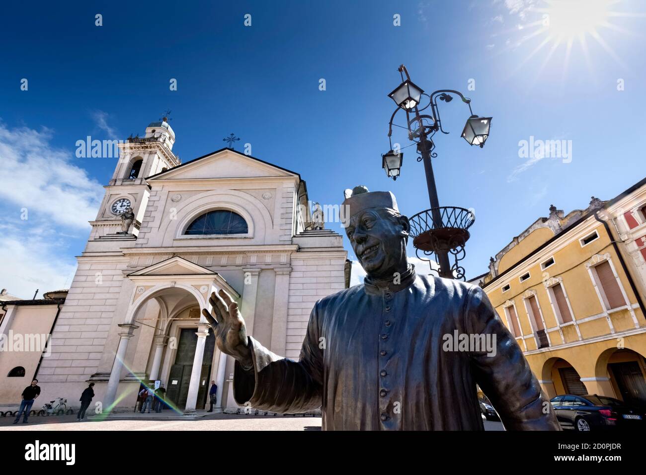 Brescello: the statue of Don Camillo and the Santa Maria Nascente church. The village is famous for the films of Don Camillo and Peppone. Italy. Stock Photo