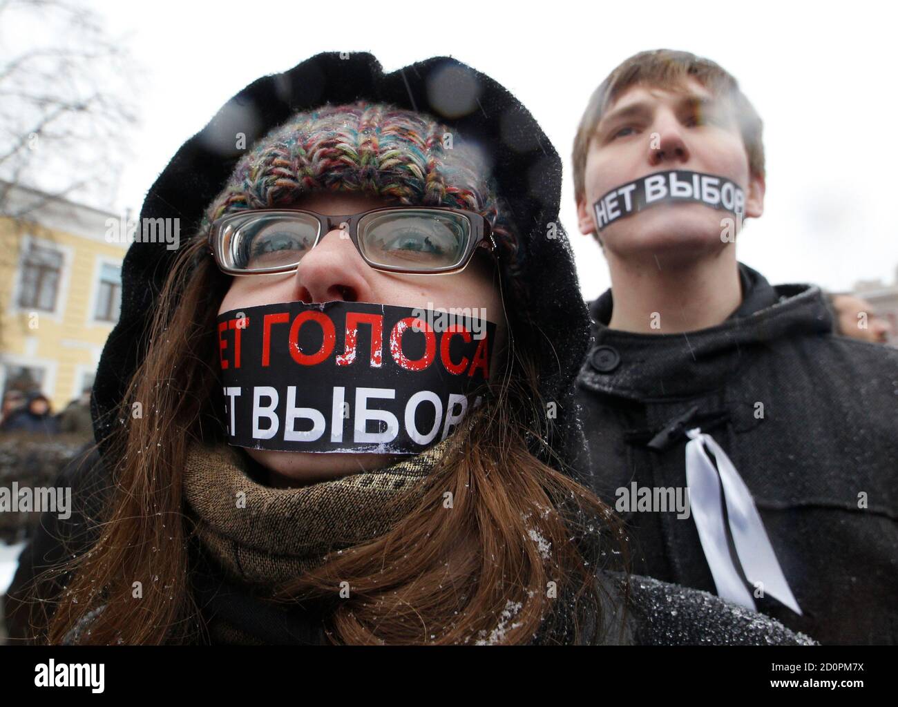 Protestors with mouths covered take part in a demonstration against recent parliamentary election results in St. Petersburg December 24, 2011. The slogan reads: 'No voice (vote), no choice (election)'. REUTERS/Alexander Demianchuk (RUSSIA - Tags: POLITICS CIVIL UNREST) Stock Photo