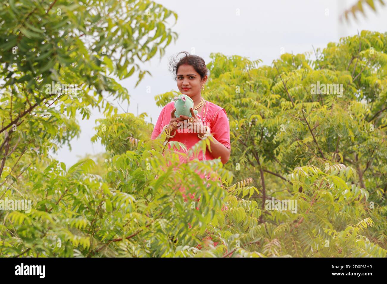 An Indian traditional woman holding a teddy bear and posing in the field, Concept to new life, married life, Pregnant, mother's love for children Stock Photo