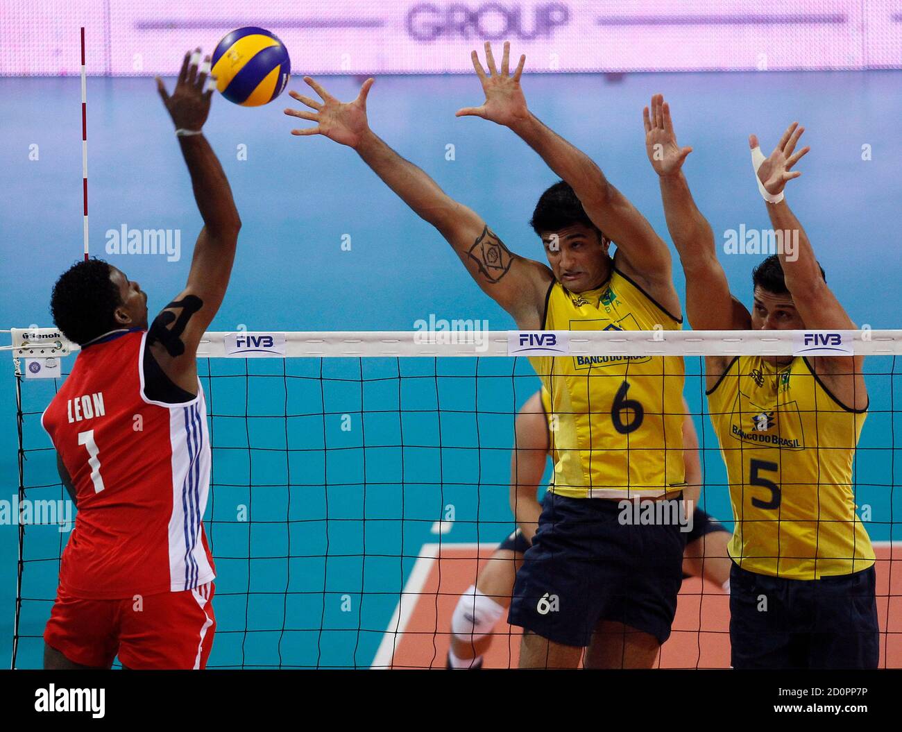 Wilfredo Leon (L) of Cuba spikes the ball against Leandro Vissotto and  Sidnei dos Santos (R) of Brazil during their FIVB World League Pool F men's  volleyball match at Arena Armeec hall