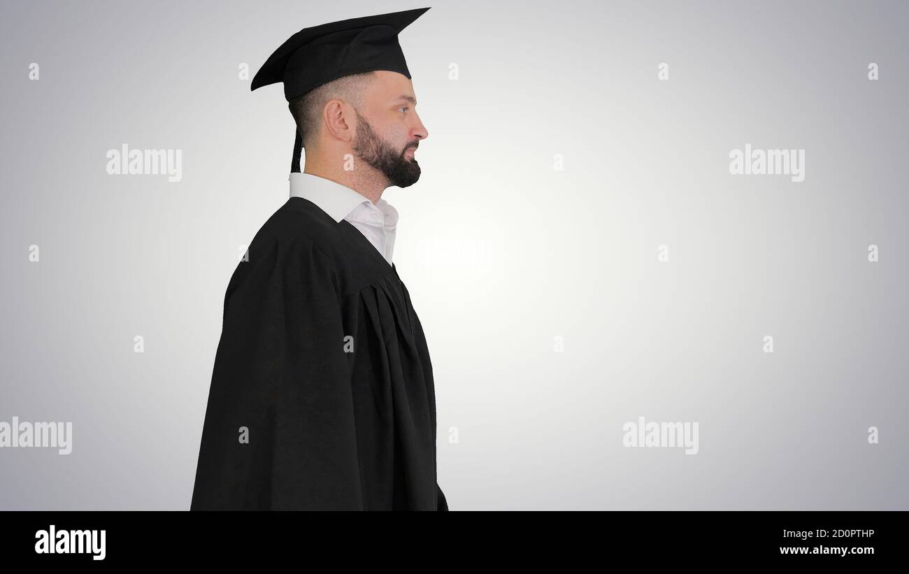 Happy graduate male student walking on gradient background Stock Photo ...