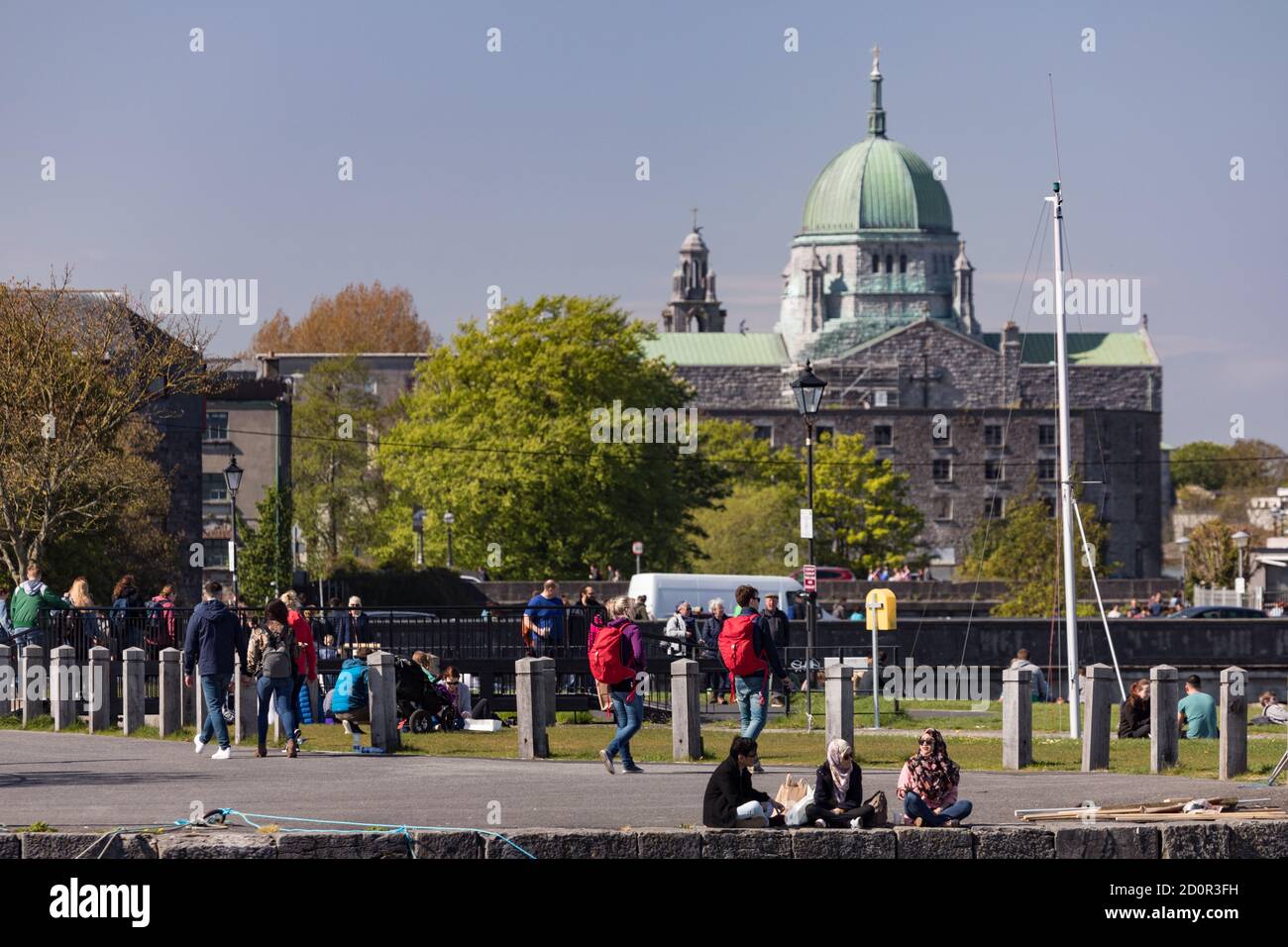 GALWAY CITY, IRELAND - 5th May, 2018: People enjoying a sunny spring day along the bank of Corrib river in the Claddagh area of Galway city, View of G Stock Photo