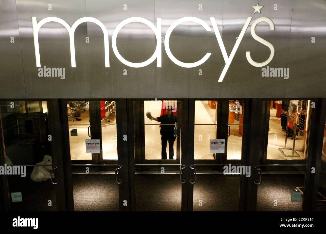 A worker cleans windows at a Macy's store in Arlington, VA ...