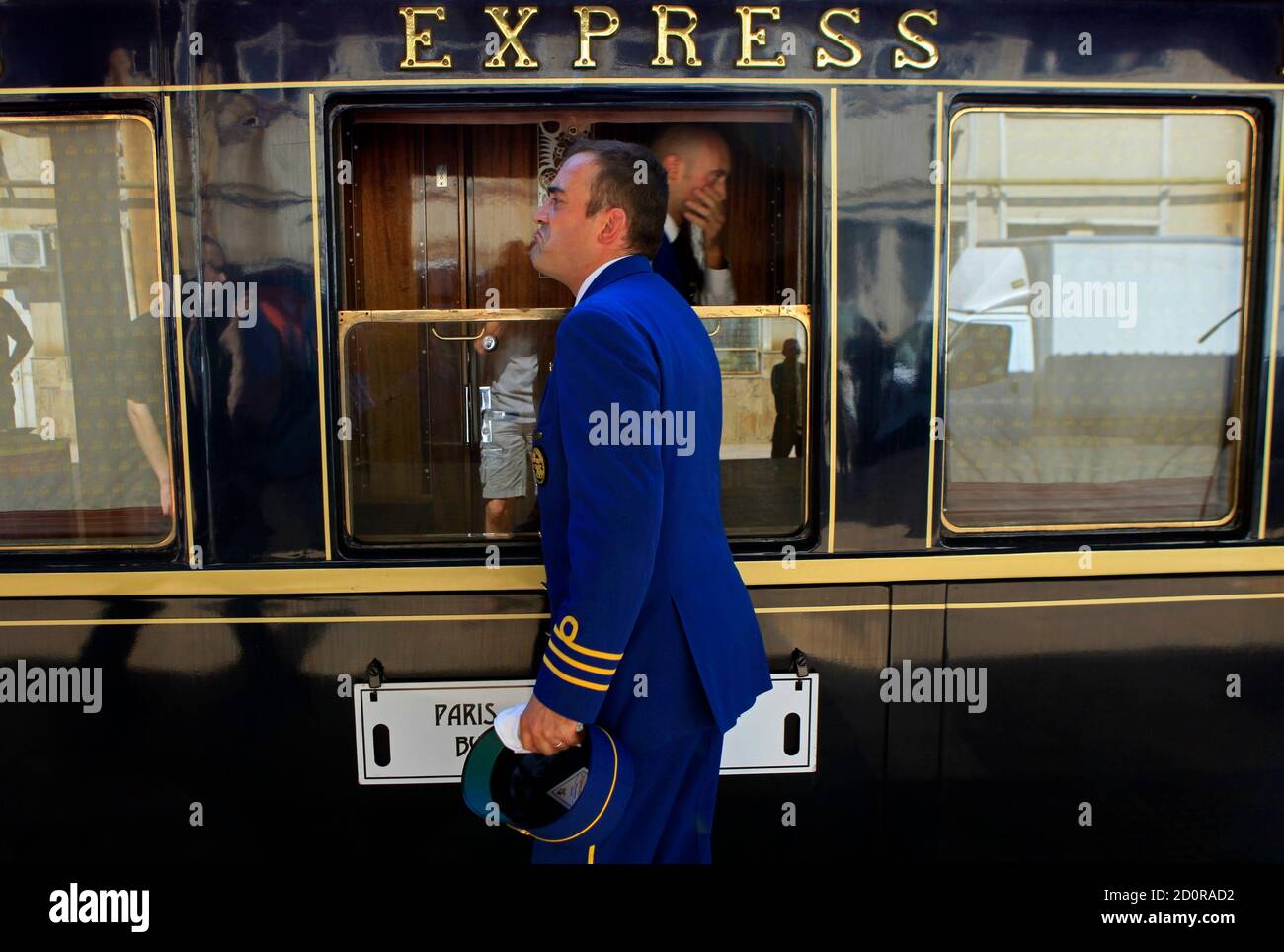 A car attendant stands in front of the Orient Express at the main railway  station in Bucharest September 3, 2012. The Venice Simplon-Orient Express  train recreates the original Orient-Express route from Paris