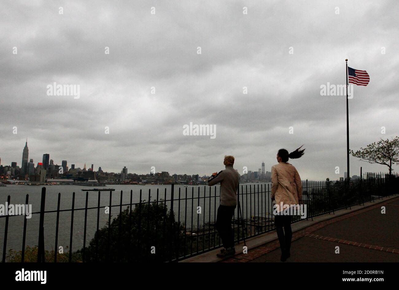 A strong wind blows as Anete Pukite (R) and Martins Alksnis of Latvia look  at the New York skyline along the Hudson River in Weehawken, New Jersey,  October 28, 2012. Tens of