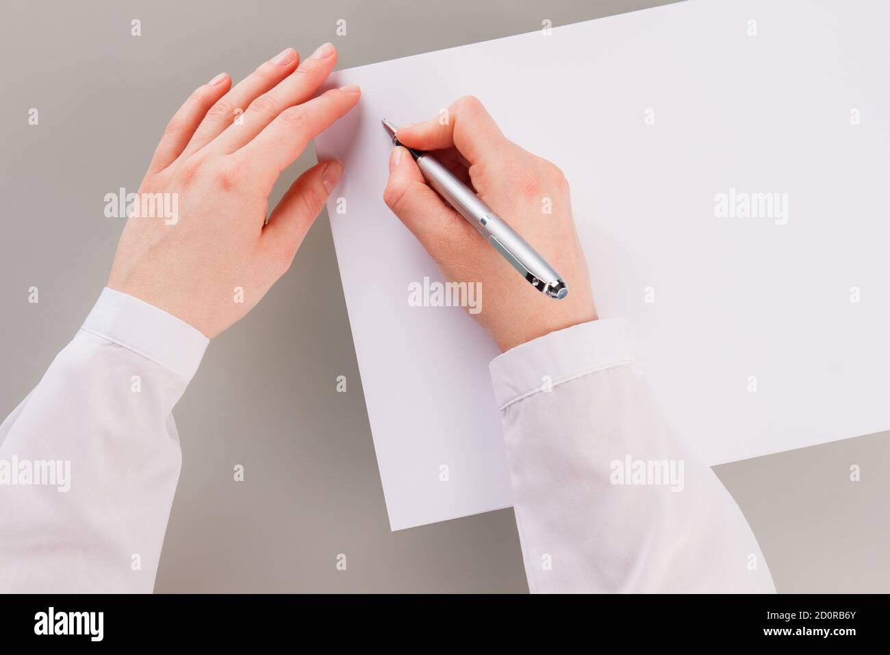 Female hand holding pen and writing on blank paper stock photo alamy