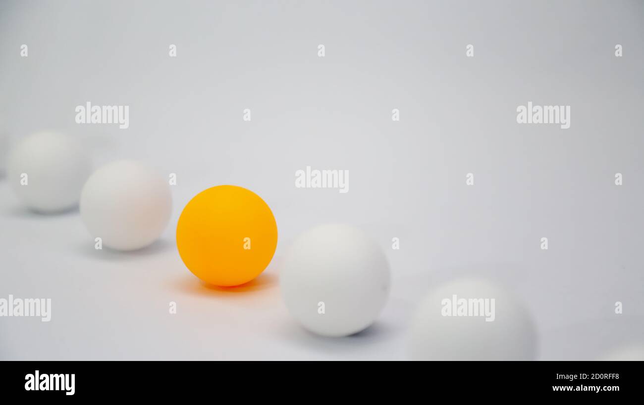 Different concept photo. An orange ball align with white ball with light background Stock Photo